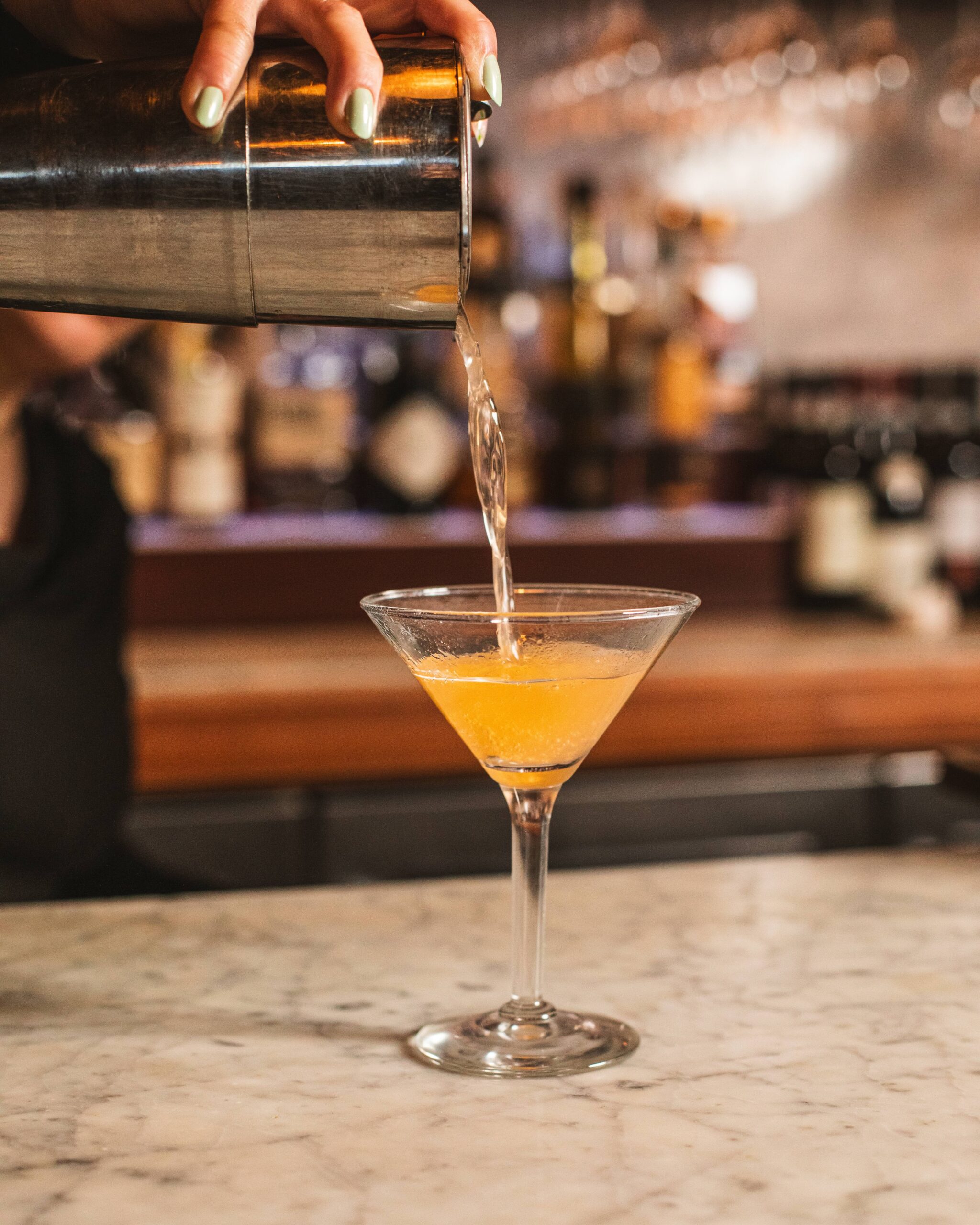 a bartender pouring a martini
