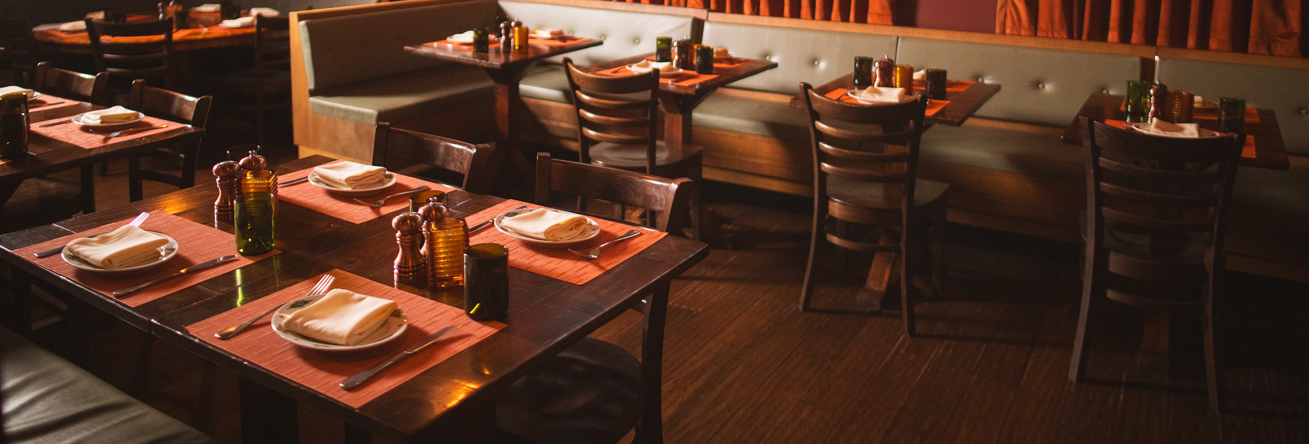 the interior of osteria morini bernardsville - light green leather banquets with wooden tables.