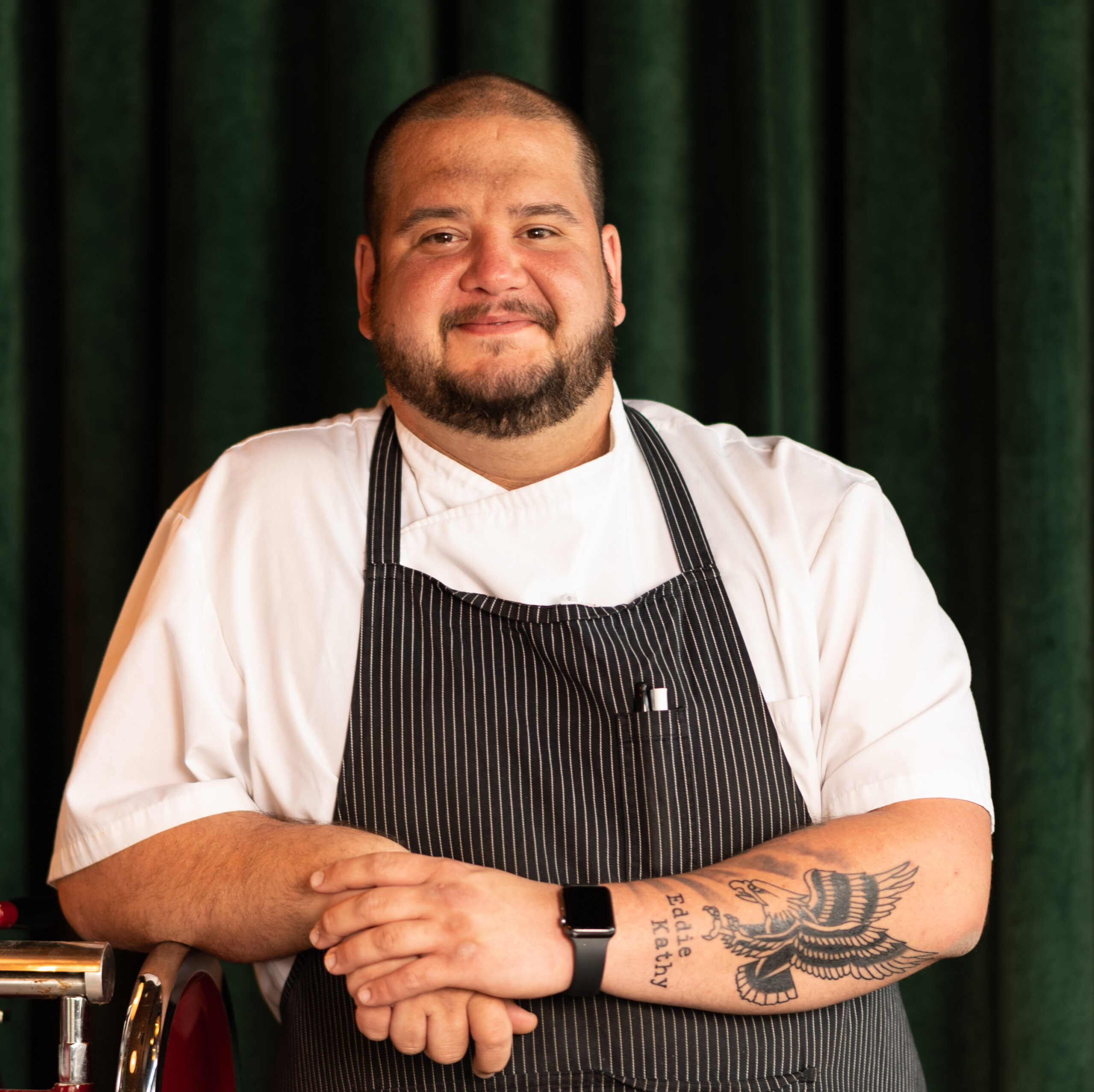 chef in an apron leaning in a headshot