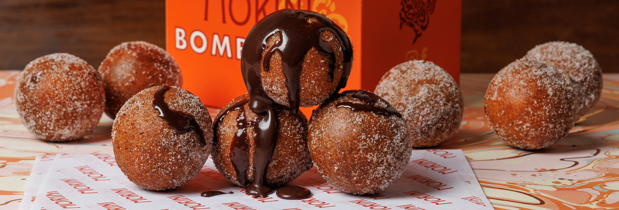 bit sized doughnuts rolled in sugar and drizzled. with chocolate