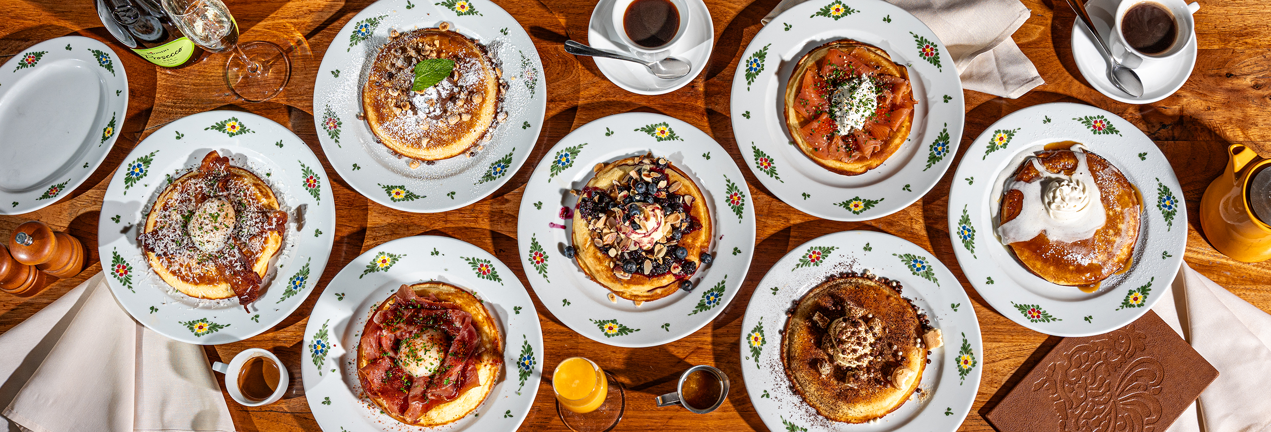 top down view of a variety of dishes holding different types of pancakes